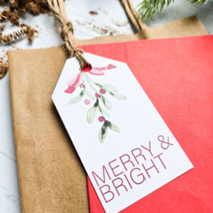 Free printable Christmas gift tag displayed on brown kraft paper bag
